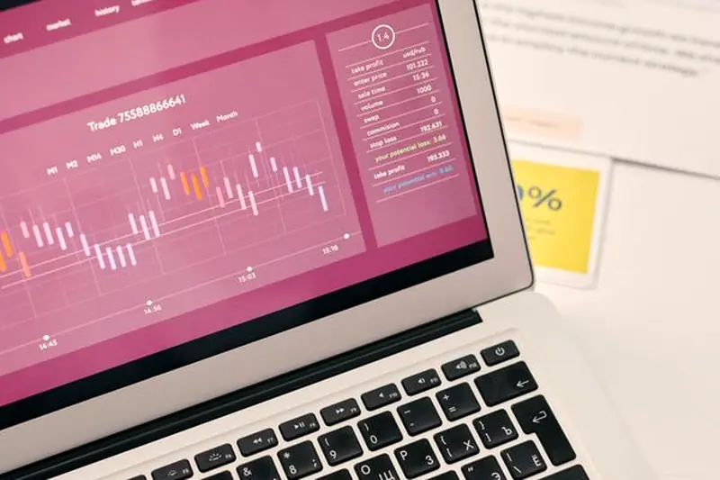 A laptop on a desk showing a website earnings and traffic chart