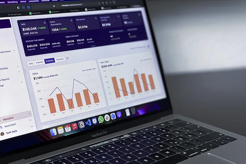 A laptop showing a website revenue and traffic analytics dashboard