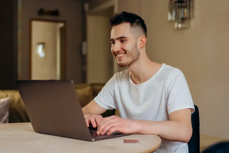 A person working on a laptop at home on a side project