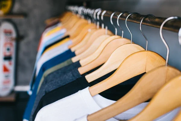 Plain t-shirts hanging on a rack in a small clothing shop