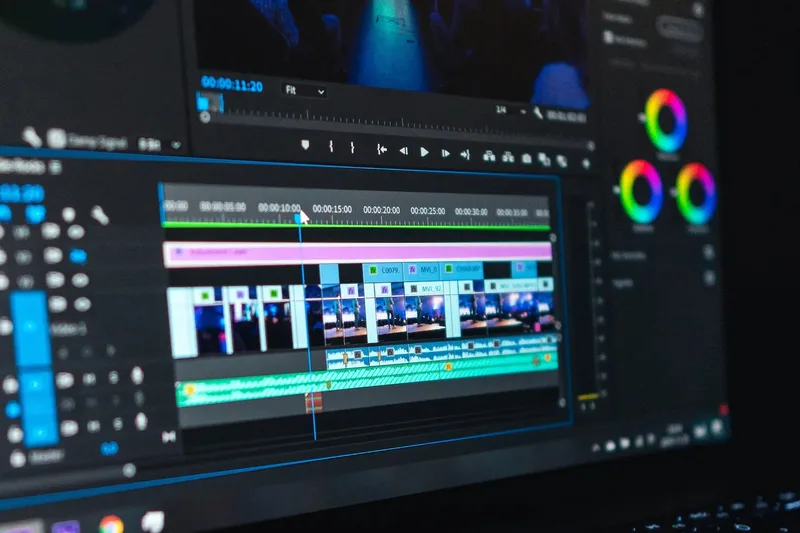 A video editing timeline with clips and color-grading wheels on a monitor, close up