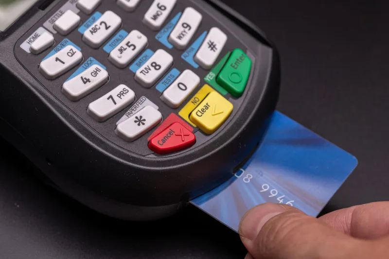 A credit card inserted into a payment terminal, close up