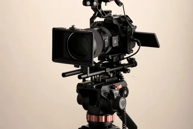 A professional video camera on a tripod in a studio, with no person in frame