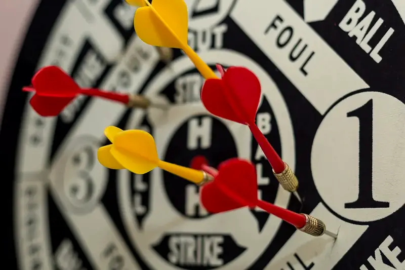 Red and yellow darts hitting a target, close up