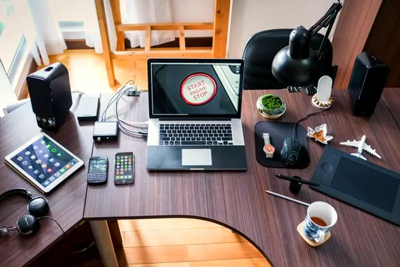 A tidy desk with a laptop, tablet, and work tools seen from above