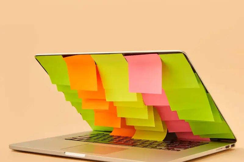 A laptop covered in colorful sticky notes full of product ideas
