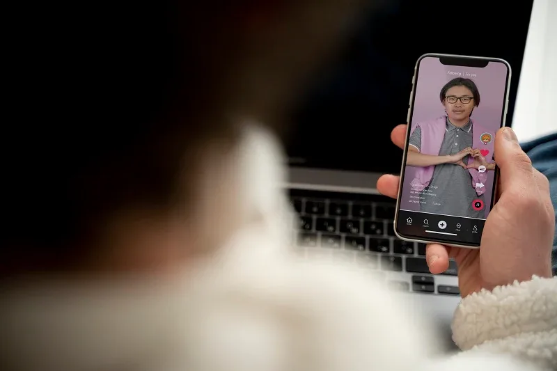 A person holding a smartphone, watching a short-form vertical video